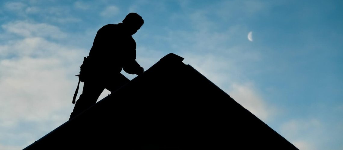 contractor-in-silhouette-working-on-a-roof-top